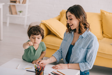 Wall Mural - excited mother and son drawing with color pencils in living room