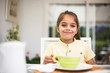 © Westend61 - Portrait of smiling little girl having breakfast at home