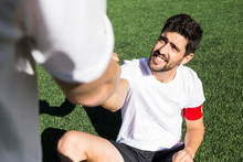 Football Player Helping An Injured Player During A Match