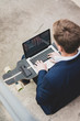 © Westend61 - Young businessman with skateboard sitting outdoors on stairs using laptop