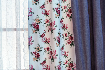 Curtains with floral pattern on the living room window.