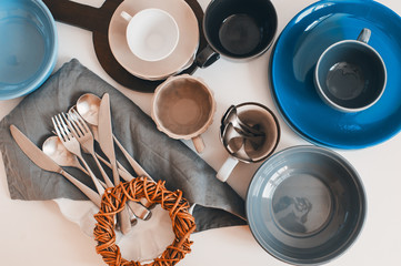 Wall Mural - top view of ceramic tableware and cutlery in soft pastel neutral tones. Modern tableware for home