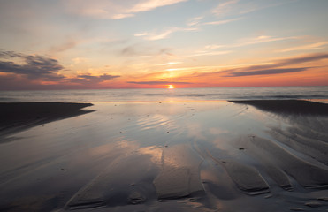 Poster - Beutiful sunset and formations in the sand made by the water of the ocean