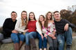 © Cavan Images - Big Happy Family of Teenagers Sits on Top of Hay Bales at Sunset