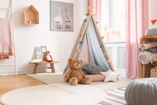 Teddy Bear And Star Pillow In Front Of Tent In Child's Room Interior With Pouf And Poster. Real Photo