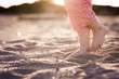 © Cavan Images - Feet of little girl in sand at beach in evening light with toe nails