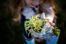 Little Girl Holding And Smiling At Green Succulent Plant