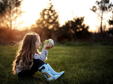 Young Girl Sitting On Grass In Park