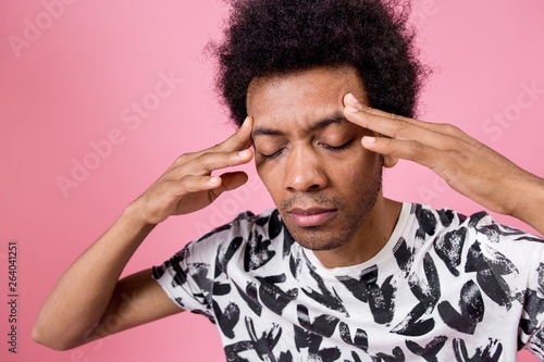 Fotografía Curly African man trying to remember holding his head closed his eyes