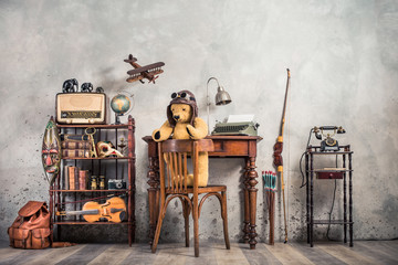 Wall Mural - Retro Teddy Bear toy on chair, typewriter, desk lamp, vintage telephone on stand, old books, radio, globe,  binoculars, carnival mask, photo camera, fiddle on shelf, wooden plane, travel backpack, bow