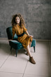 © Cavan Images - Young beautiful curly woman stands on the office in a retro dress