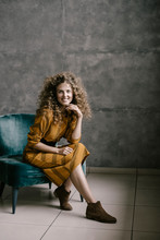 Young Beautiful Curly Woman Stands On The Office In A Retro Dress
