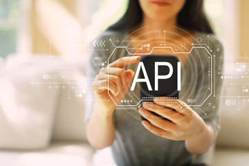 api concept with woman using her smartphone in a living room