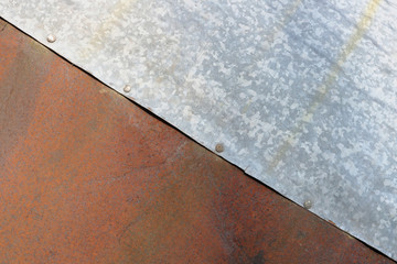 Wall Mural - Sheets of rusty red and estimated silver steel are riveted together