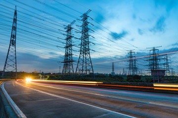 Wall Mural - High voltage, high speed road car track in the background of high voltage towers