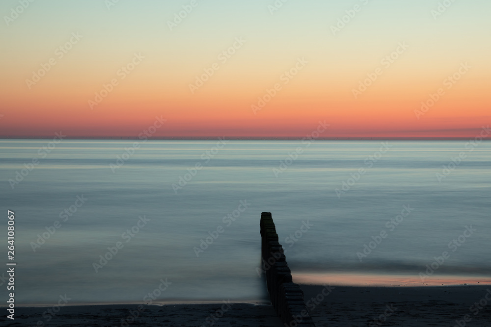 groyne at dawn in time exposure as sea burial concept - obrazy, fototapety, plakaty 