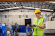© twinsterphoto - Asian male Industrial engineer in hard hat working with laptop in safety jacket at heavy industry manufacturing factory. Processing plastic injection molding industry