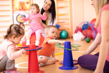 Little kids with their mothers in kindergarten gym