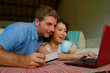 © TheVisualsYouNeed - young happy and beautiful mixed ethnicity couple with Caucasian husband or boyfriend and Asian Chinese woman wife or girlfriend shopping online together at home