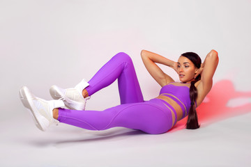 Wall Mural - Strong athletic woman, doing exercise on white background wearing sportswear. Fitness and sport motivation.