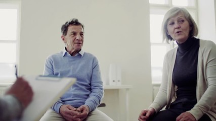 Wall Mural - Men and women sitting in a circle during group therapy, talking.