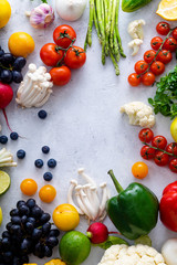 Top view flat lay with various vegetables on concrete background. Enoki mushrooms, asparagus, cherry tomatoes and berries. Summer food ingredients concept