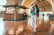 © PR Image Factory - full length young asian girl tourist walking indoor sightseeing looking enjoy restored art deco interior of Union Station while travel by train in america. background passengers ask information desk