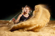 Female long jump athlete landing in sandpit