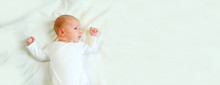 Banner Portrait Little Baby Boy Newborn 1 Months Old In White Clothes Lying On His Back In His Crib. Concept Of Health And Children. Selective Focus.