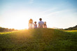 © Blue Jean Images - Happy young family sitting on meadow