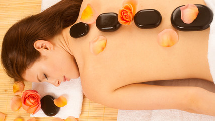 Wall Mural - Stone therapy. Woman getting a hot stone massage at spa salon