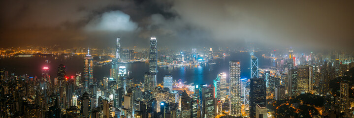 Wall Mural - Panorama aerial view of Hong Kong City skyline at night over the clouds