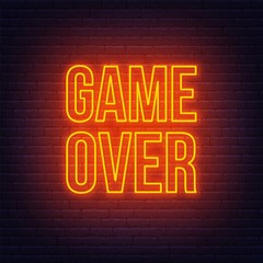 Neon game over sign on brick wall background.