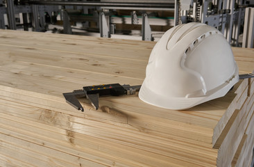 Safety white building helmet on wooden board.