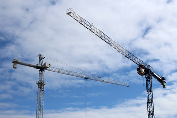 Construction site tower cranes against blue sky