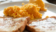 Scrambled eggs and toast. Focus is on scrambled eggs