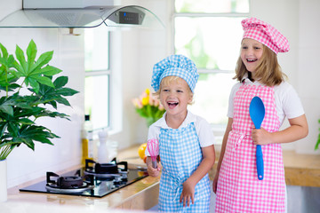 Wall Mural - Kids cook in white kitchen. Children cooking.