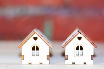 Two small wooden houses on a red brick background