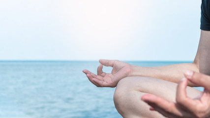 Wall Mural - Mantra yoga meditation, spiritual mental health practice with woman in lotus pose having peaceful mind relaxation on the beach outdoor training with cool morning sky