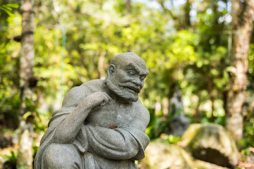 stone ruined Arhat statue in forest