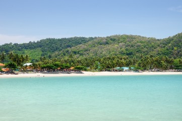 Tropical turquoise sea bay, paradise sandy beach, palm trees, tourist resorts, Haad Kwang Pao Beach in Khanom district of Nakhon Si Thammarat province of Thailand.