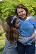 © Glenn Highcove - Latina Mother and Daughter Smiling and laughing outside in back yard