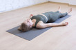© junky_jess - Woman laying on mat in relaxing pose on the floor. Yoga class, the shavasana.
