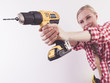 © Voyagerix - Woman using drill on wall