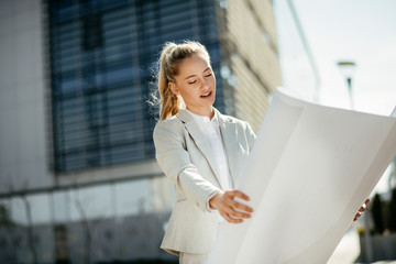 Wall Mural - Architect presenting a new plan. Businesswoman with blueprints.	