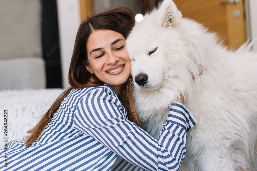 Cute girl petting her dog. Beautiful girl having fun with her dog and