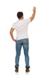 © studioloco - Young Man In Jeans And White T-shirt Is Standing And Waving Hand. Rear View