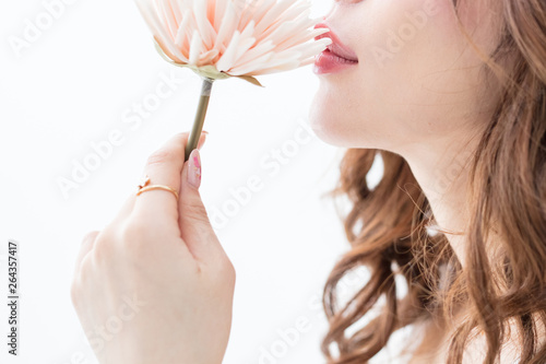 白背景に茶髪の巻き髪をした綺麗な女性が花をもって上を向いている姿キャバクラモデル美人 Photo Stock Adobe Stock