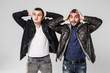 © F8  \ Suport Ukraine - Two displeased men , look with sullen expression, feel like loosers after loosing game, dressed in fashionable denim clothes, stand next to each other over white background.