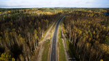 Fototapeta Na ścianę - Aerial view of country road through the forest in autumn. drone photography